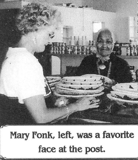 A woman stands at a counter with several pies, while an older woman sits behind the counter smiling. Text below reads: "Mary Fonk, left, was a favorite face at the post.