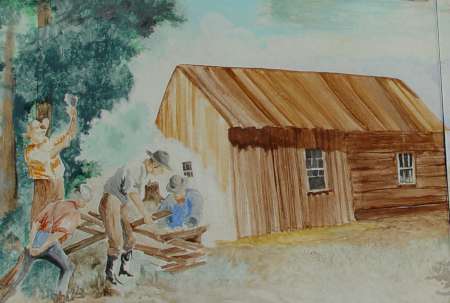 A group of people build a wooden fence near a rustic log cabin with a metal roof, surrounded by trees and grass under a partly cloudy sky.