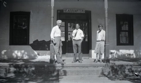 Three people stand on the steps outside a building labeled "Headquarters.