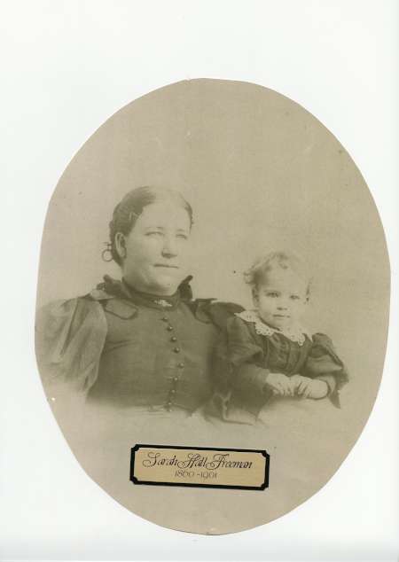 Sepia-toned portrait of a woman in buttoned dress with puffed sleeves sitting beside a young child. Text below reads: "Sarah Hall Freeman 1850-1904.