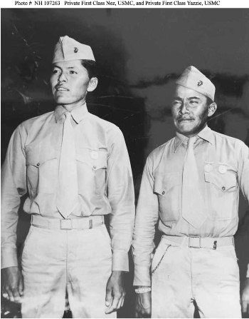 Two US Marines in uniform stand side by side, facing forward, in a black and white photograph.