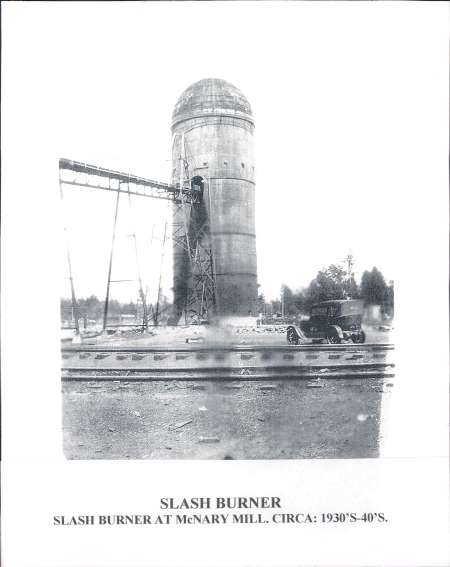Historic photo of a tall slash burner with scaffolding, adjacent to an early truck at McNary Mill, circa 1930s-40s.
